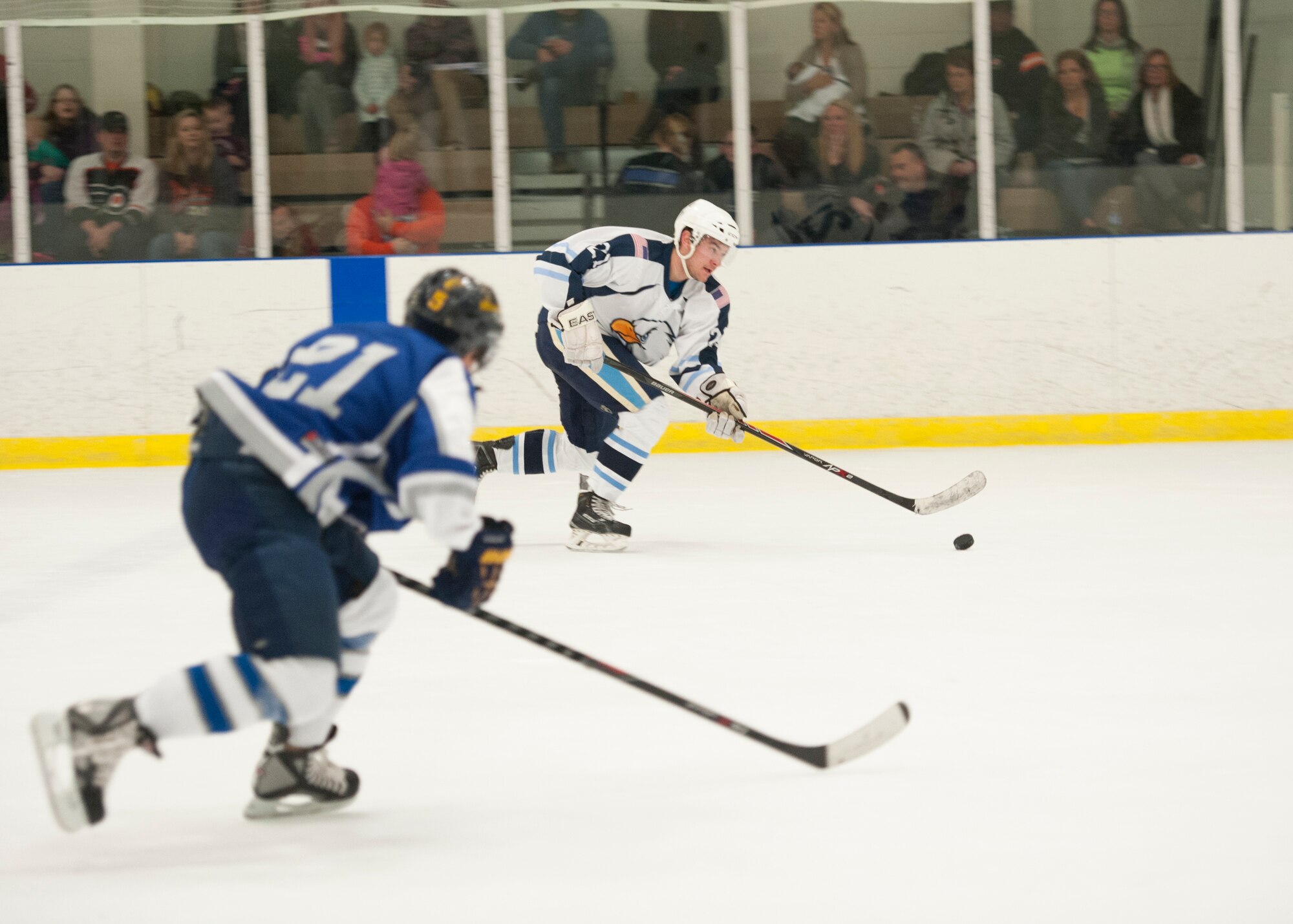 Sam Ernst, Dover Eagles center, carries the puck into the offensive zone during a charity hockey game March 13, 2016, at the Centre Ice Rink in Harrington, Del. The Eagles play the Fraternal Order of Police Lodge 15 hockey team annually in a charity game. (U.S. Air Force photo/Senior Airman Zachary Cacicia)