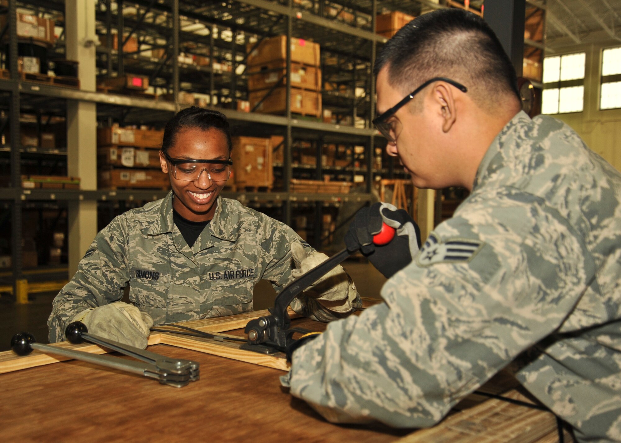 Airman 1st Class Patrice Simons, 92nd Logistics Readiness Squadron traffic management apprentice, assists Senior Airman Johnraphael Navarro, 92nd LRS traffic management journeyman, in closing up a crate March 18, 2016, at Fairchild Air Force Base, Wash. The packaging process includes making sure the item has the correct stock number and proper documentation. After that they will check to ensure the cushioning is adequate for protecting the item and tape up the box, or in some instances they will build a crate for shipping. (U.S Air Force photo/Airman 1st Class Taylor Bourgeous)