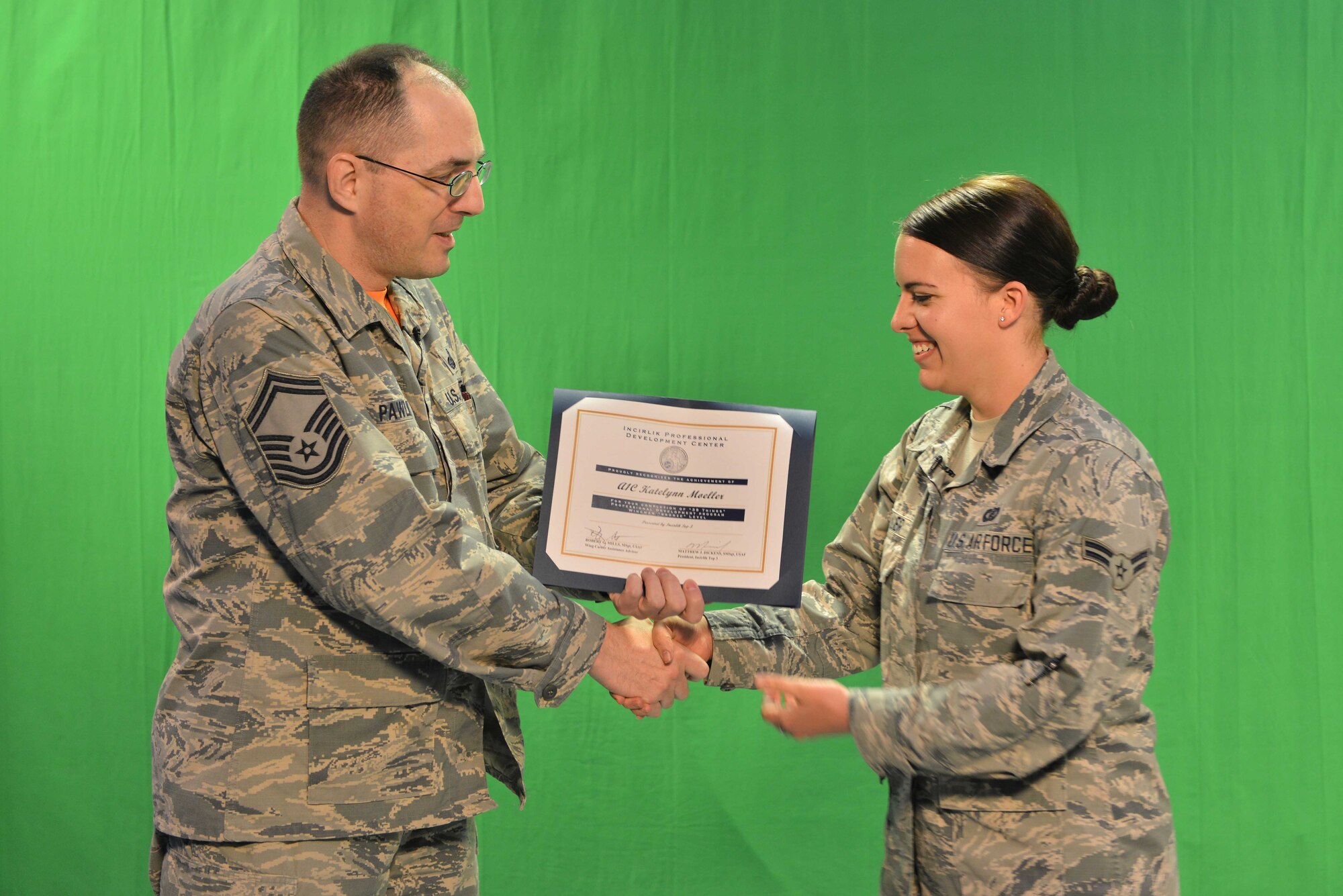 U.S. Air Force Senior Master Sgt. Kevin Pawlik, 39th Communications Squadron plans and programs flight superintendent, presents U.S. Air Force Airman 1st Class Katie Moeller, American Forces Network Incirlik broadcast producer, with a Titan University, “wingman level” award, March 11, 2016, at Incirlik Air Base, Turkey. The wingman level award requirements consist of three core classes, one intermediate class, one primary class, and a two-page essay. (U.S. Air Force photo by Senior Airman John Nieves Camacho/Released)