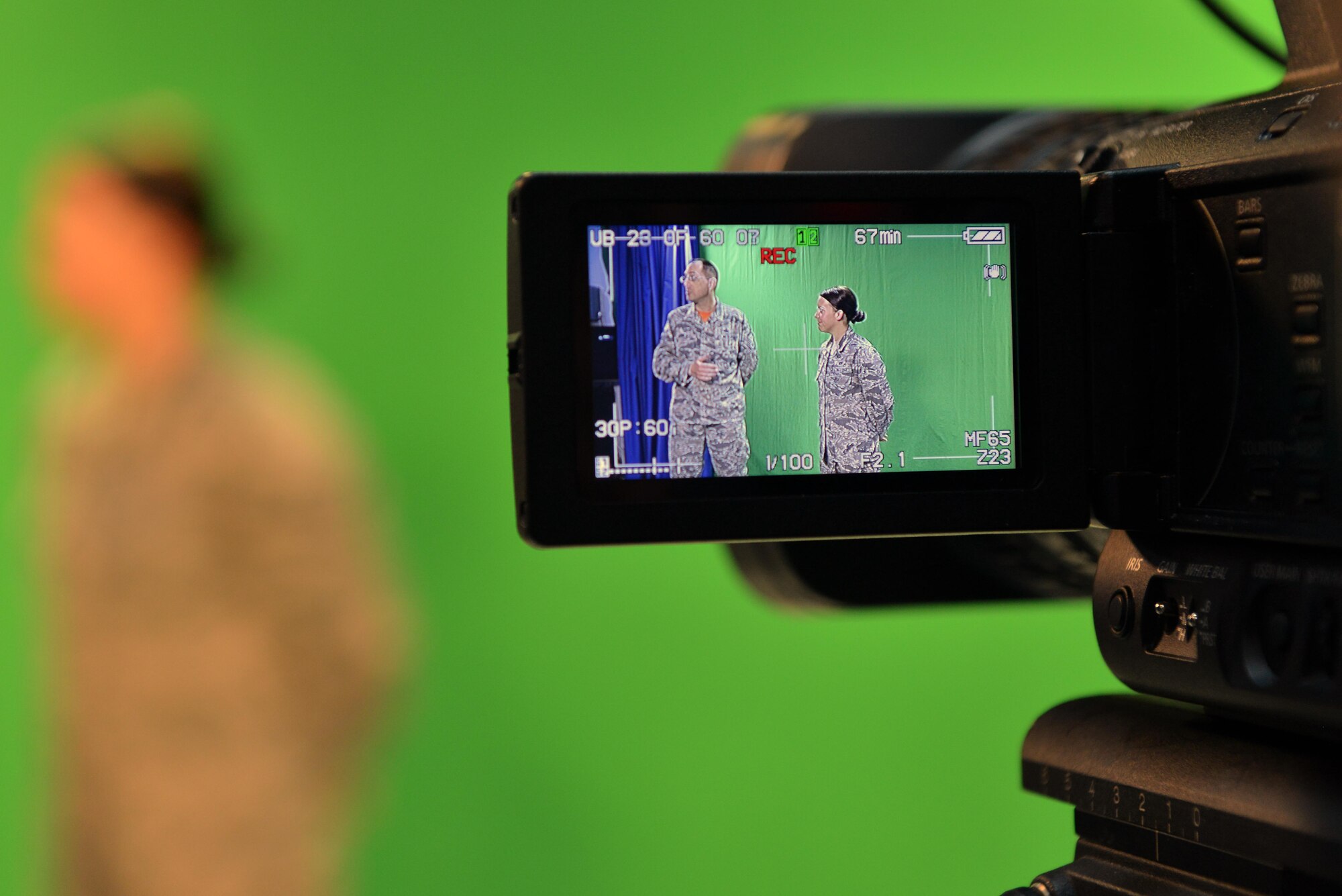 Viewed through a video camera, U.S. Air Force Senior Master Sgt. Kevin Pawlik, 39th Communications Squadron plans and programs flight superintendent, speaks about Titan University beside U.S. Air Force Airman 1st Class Katie Moeller, American Forces Network Incirlik broadcast producer, March 11, 2016, at Incirlik Air Base, Turkey. Titan University is Incirlik’s professional development program and is geared toward promoting professional growth through the Air Force ranks. (U.S. Air Force photo by Senior Airman John Nieves Camacho/Released)