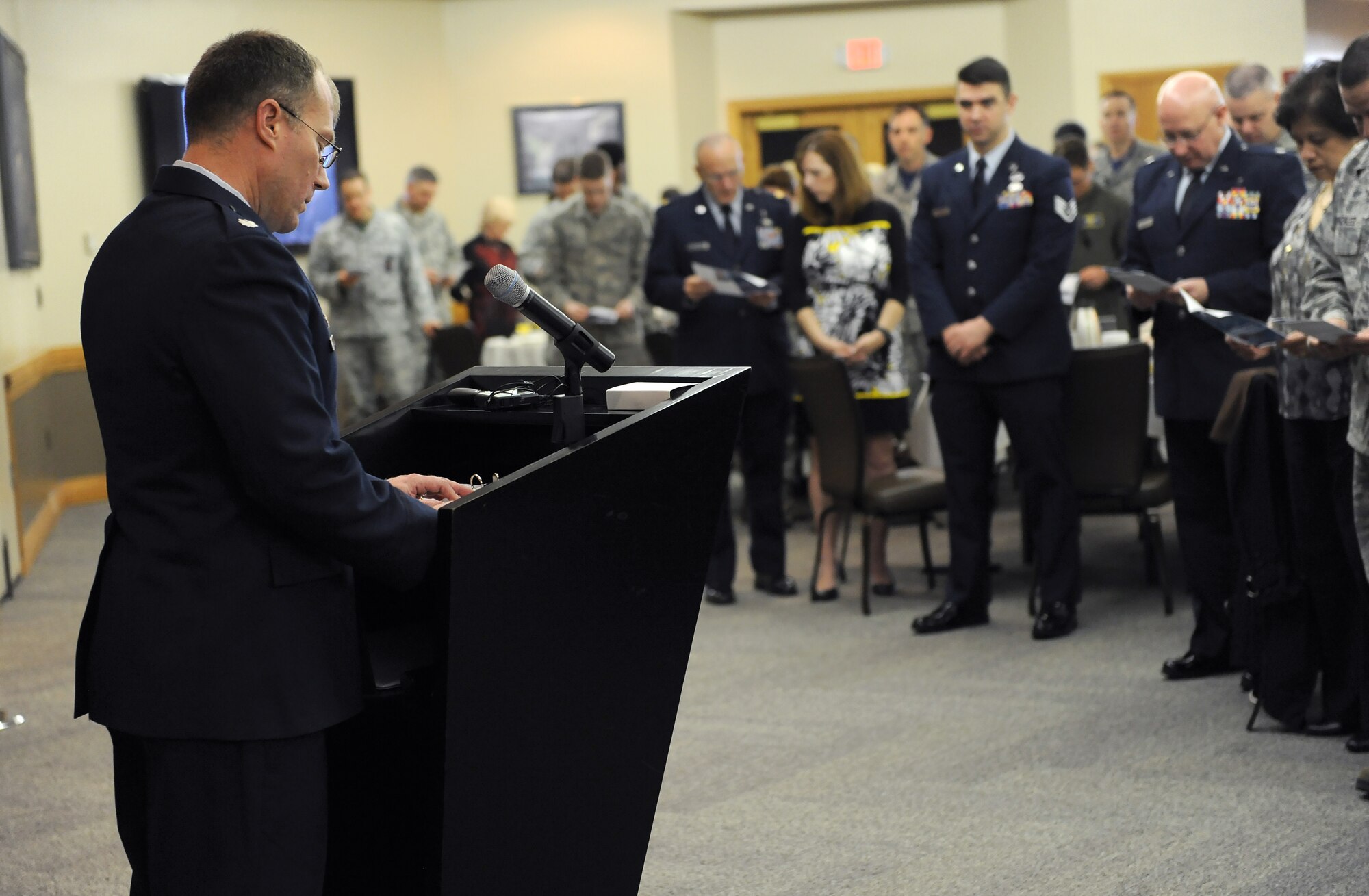 U.S. Air Force Lt. Col. Lance McInnish, the 509th Bomb Wing director of staff, leads members of Team Whiteman in prayer during the National Prayer Breakfast at Whiteman Air Force Base, Mo., March 11, 2016. The prayer was derived from the 2nd inaugural speech by President Abraham Lincoln. (U.S. Air Force photo by Airman 1st Class Michaela R. Slanchik)