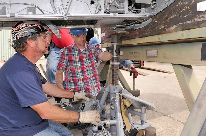 Tony Faircloth, Museum of Aviation restoration specialist, and Tony Day, restoration supervisor, position the fuselage of the F-100 Super Sabre in preparation for attachment of the wings. The wing attachment to the aircraft – which was flown by retired Gen. Rick Goddard during the Vietnam War – marks a milestone towards getting the aircraft to its final resting place inside the museum’s Hangar One. (U.S. Air Force photo by Tommie Horton)
