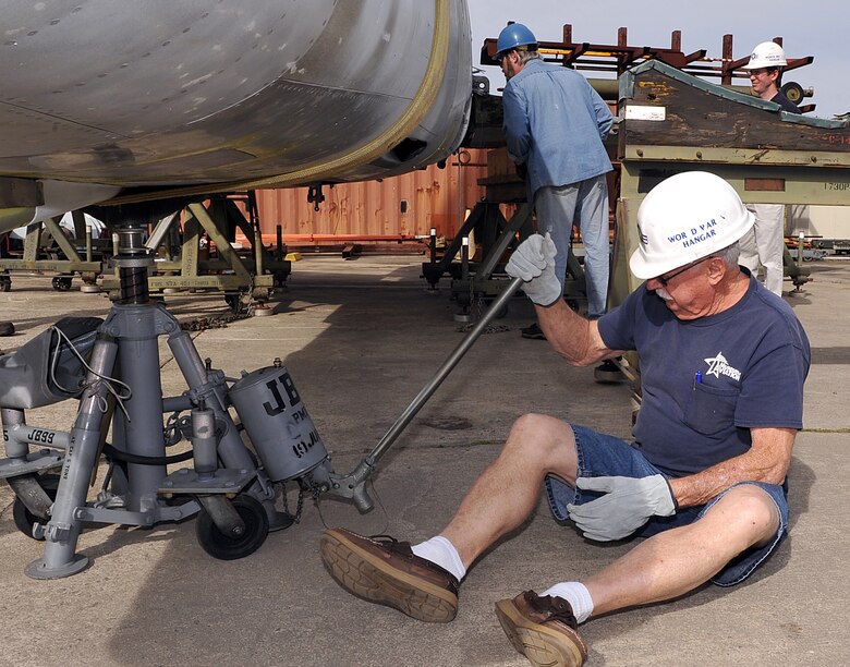 Bob Denison, museum volunteer, uses a jack to help position the fuselage of the F-100 Super Sabre for the wing project March 11, 2016. (U.S. Air Force photo by Tommie Horton)
