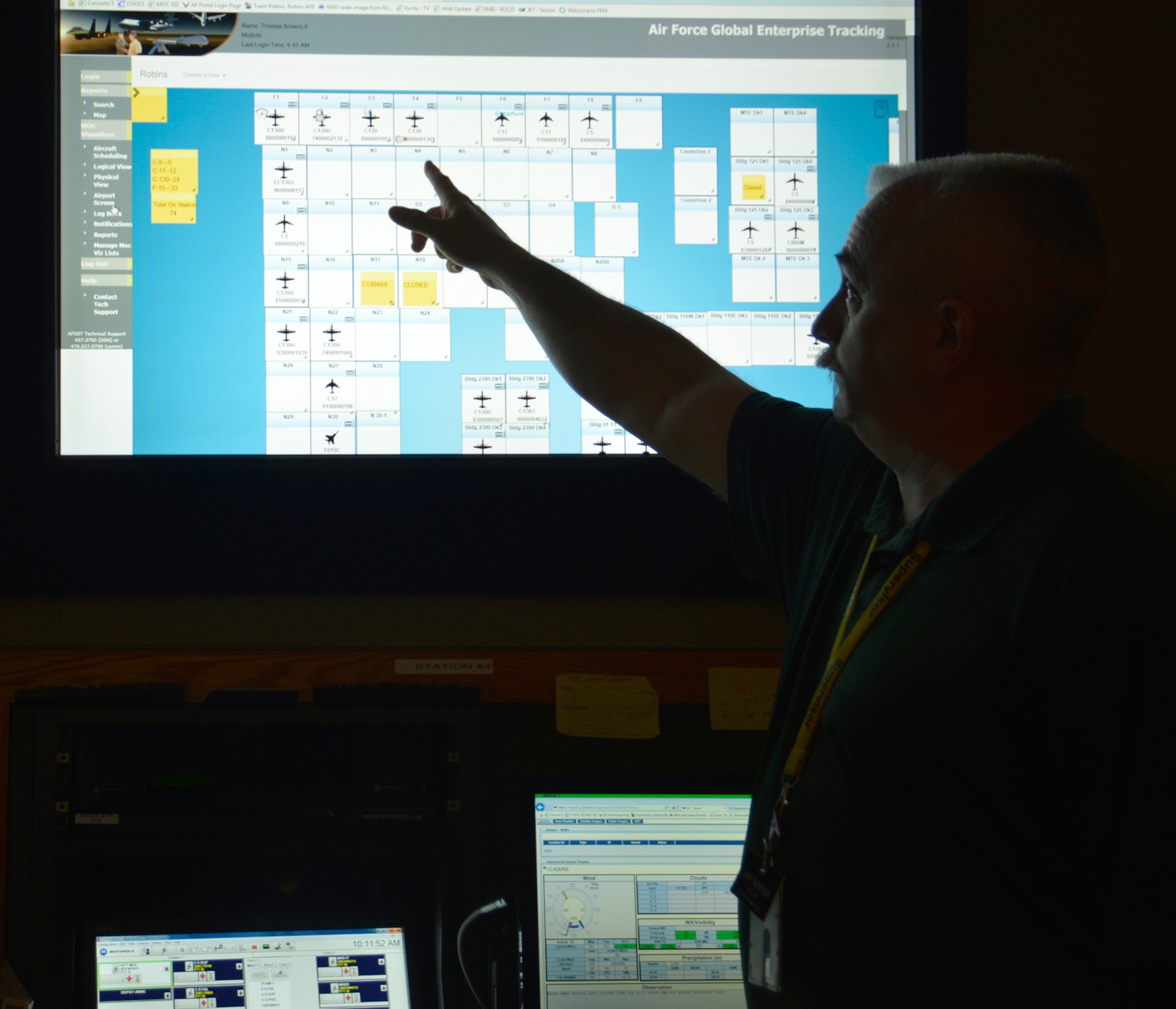 John Nicholson, Maintenance Operations Center chief, shows aircraft locations on the Maintenance Operations Center Visualizer. The MOC is a 24/7 operation that assists efforts on the Robins flight line. The MOC's responsibilities are varied, from supporting maintenance professionals with aerospace ground equipment and tracking injuries and incidents, to alerting personnel of inclement weather and keeping eyes on the locations of every aircraft on station. (U.S. Air Force photo by Ed Aspera)