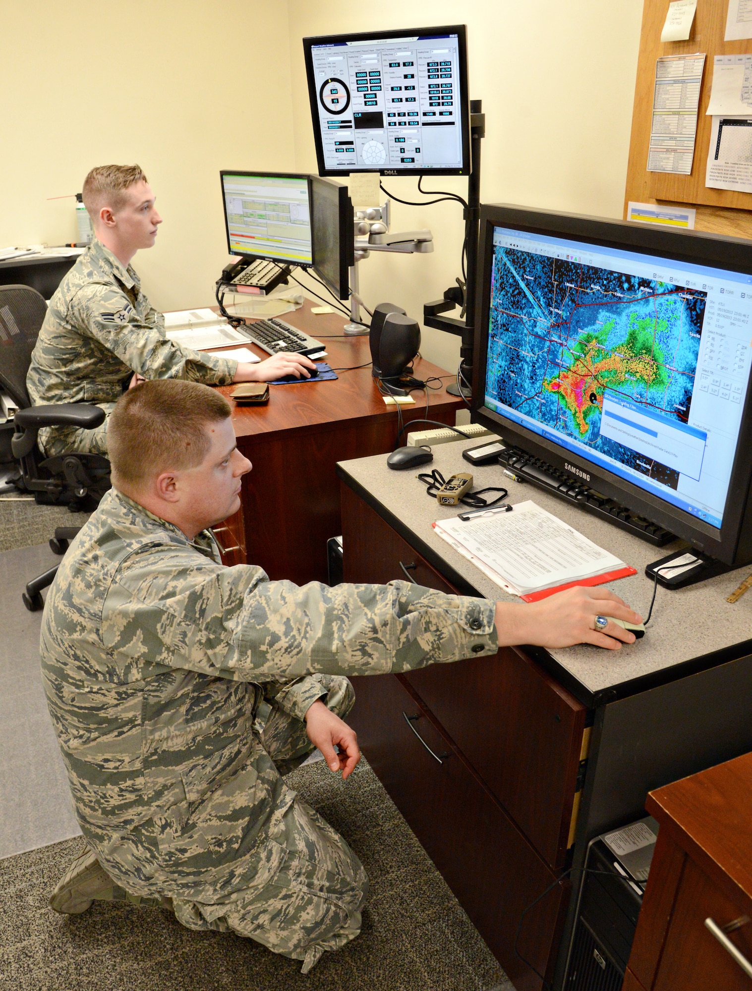 Airman 1st Class William Russell, back, a weather apprentice with the 72nd Operational Support Squadron, monitors weather data on Air Force Weather Web Services while Capt. Adam Bennett, flight commander of the weather flight, looks at radar data from the May 19, 2013, storm/tornado system that hit Shawnee. Patterns in storms from year to year can help the weather personnel gain a better understanding of future storms. (Air Force photo by Kelly White)
