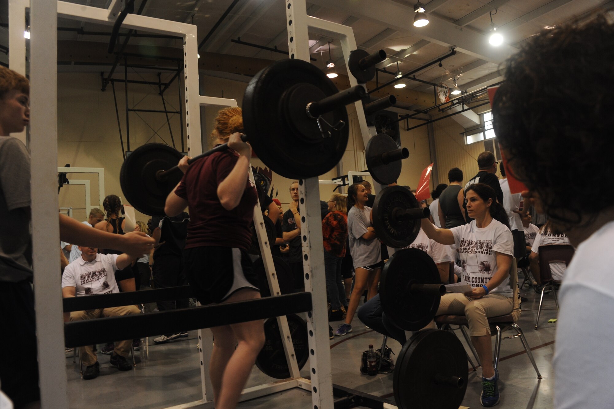 Capt. Lori Alix, Holm Center curriculum developer and Officer Training School instructor, holds up a red card signaling that the athlete’s form was unacceptable during the Alabama State Powerlifting Championships March 12, 2016, at Eclectic, Alabama. (U.S. Air Force photo by Airman 1st Class Alexa Culbert) 