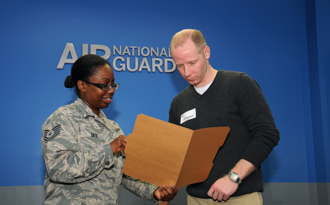 Tech. Sgt. Jovan K. Tate, a retention office manager assistant for the 111th Force Support Squadron, runs through a checklist with Airman 1st Class Andrew Wagner, a member of the 111th Attack Wing Student Flight and slated to enter the 111th Cyberspace Operations Squadron, March 13, 2016 at Horsham Air Guard Station, Pa. Tate explained the benefits that Wagner will have available to him as a Guardsman. (U.S. Air National Guard photo by Staff Sgt. Michael Shaffer)