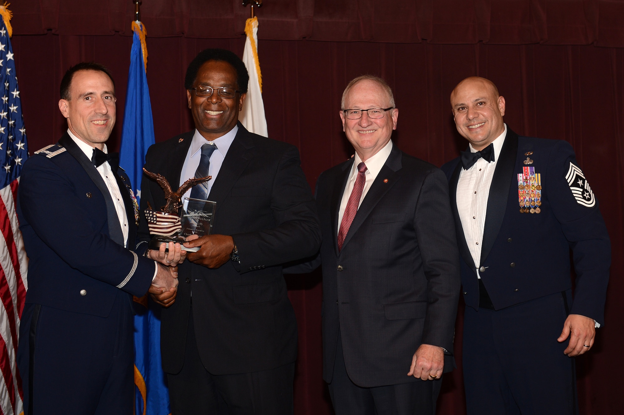 Col. Leonard Kosinski (left), 62nd Airlift Wing commander, presents the Bryce Lilly Service Award to Mr. Charles Thornton (middle left), Joint Base Lewis-McChord Department of Services joint operations officer, during the 2015 Team McChord Annual Awards ceremony March 11, 2016 at JBLM, Wash. The Bryce Lilly Service Award is given at the discretion of the wing commander to any person directly involved in enhancing the quality of military community at McChord Field. (U.S. Air Force photo/Senior Airman Divine Cox)