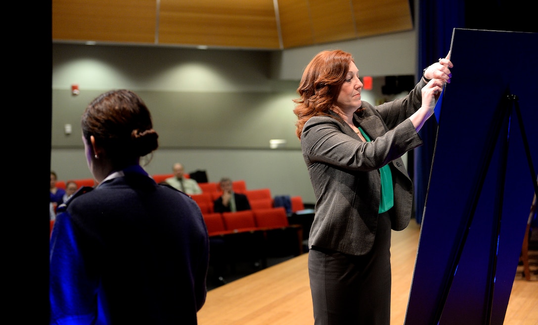 Lisa Surette pins to a sign a sexual assault victim’s testimonial which she read aloud during a Sexual Assault Awareness Month event hosted by the Air Force's top leaders at the Pentagon, March 17, 2016. Air Force photo by Scott M. Ash