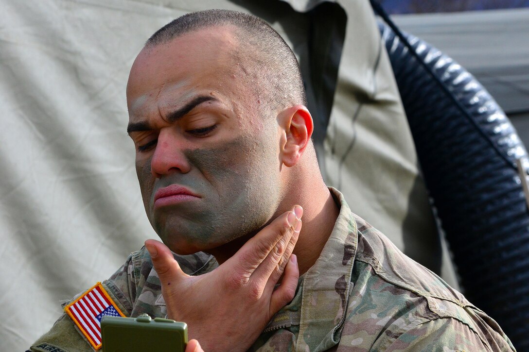 Army Staff Sgt. Pablo Caraballo applies camouflage face paint before a live-fire exercise as part of Rock Sokol at Pocek Range in Postojna, Slovenia, March 16, 2016. The bilateral exercise between U.S. and Slovenian forces focuses on small-unit tactics and enhancing readiness. Caraballo is a paratrooper assigned to 2nd Battalion, 503rd Infantry Regiment, 173rd Airborne Brigade.  Army photo by Paolo Bovo