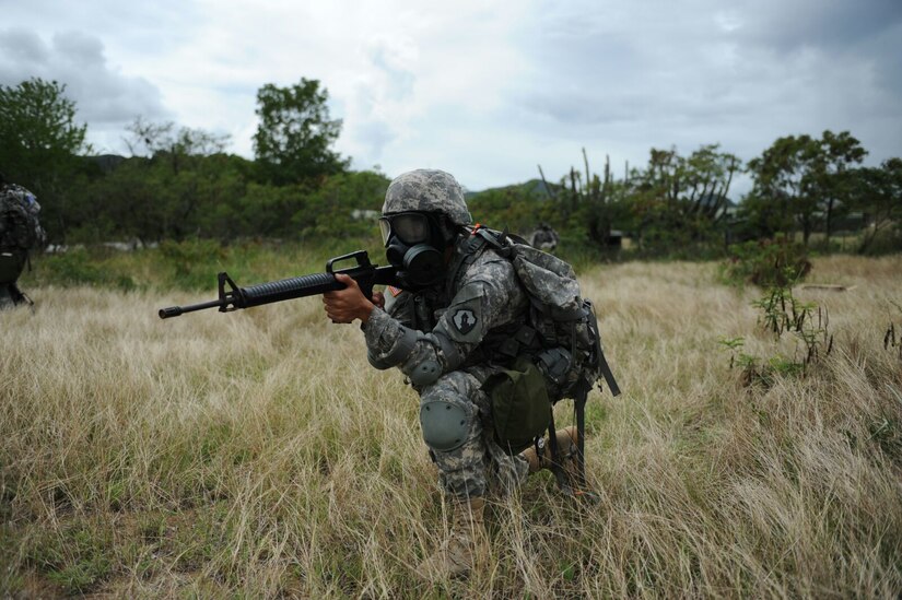 Private 1st Class Albert G. Hepburn, 346th Transportation Battalion, secures the perimeter during a CBRN exercise at the 1st MSC Best Warrior Competition on Camp Santiago, Puerto Rico, March 15.