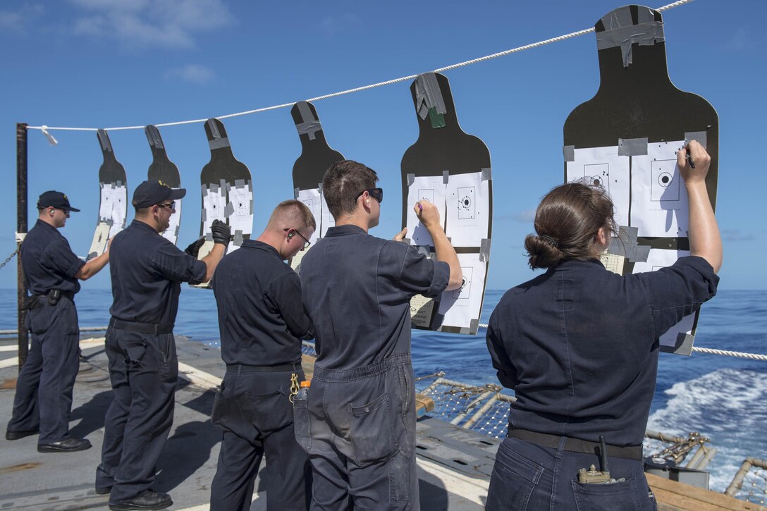 Sailors tally marksmanship scores during an M4A1 carbine qualification course on the flight deck of the USS McCampbell in the Philippine Sea, March 15, 2016. The sailors are gunner's mates, and the McCampbell is supporting security and stability in the Asia-Pacific region. Navy photo by Petty Officer Bryan Jackson
