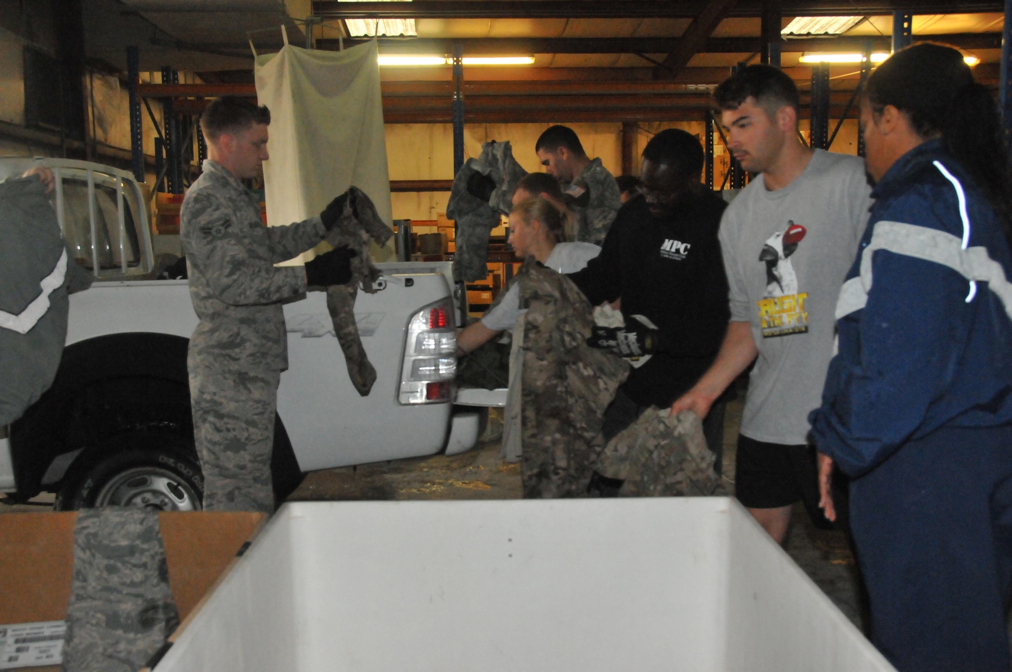 Uniform Disposal Program volunteers collect and separate uniforms into bins Mar. 3 at Al Udeid Air Base, Qatar. After uniforms are collected from the bins they are brought to the shred tent to be shredded. (U.S. Air Force photo by Tech. Sgt. Terrica Y. Jones)