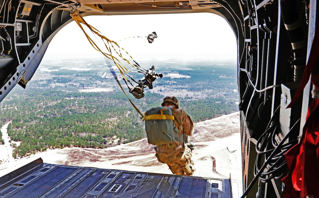 A paratrooper jumps off a Ch-47 Chinook helicopter tailgate from 1,500 feet above Sicily drop zone as part of a reenlistment jump on Fort Bragg, N.C., March 11, 2016. Army photo by Capt. Joe Bush