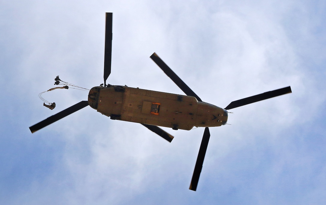 A paratrooper exits from a Ch-47 Chinook helicopter over Sicily drop zone during a reenlistment jump on Fort Bragg, N.C., March 11, 2016. Army photo by Capt. Joe Bush