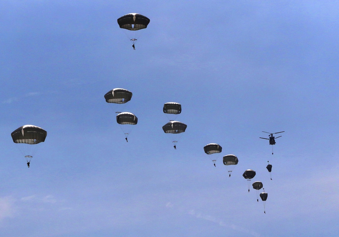 Paratroopers exit from a Ch-47 Chinook helicopter over Sicily drop zone during a reenlistment Jump on Fort Bragg, N.C., March 11, 2016. Army photo by Capt. Joe Bush