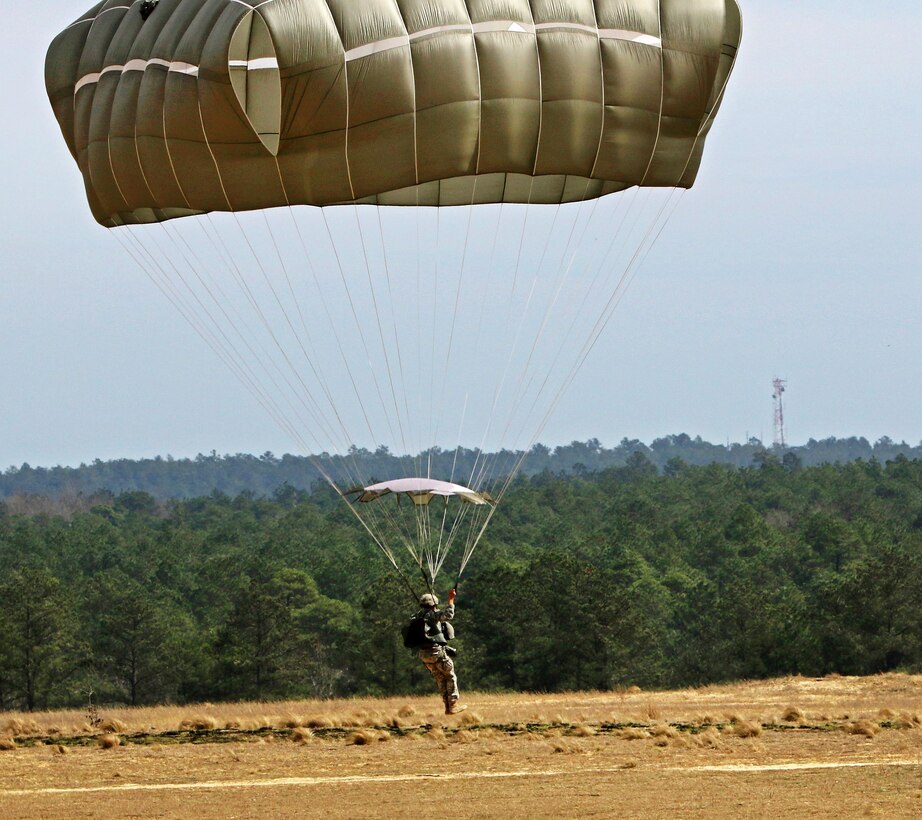 A paratrooper prepares to land after exiting a Ch-47 Chinook helicopter as part of a reenlistment jump at Sicily drop zone on Fort Bragg, N.C., March 11, 2016. Army photo by Capt. Joe Bush