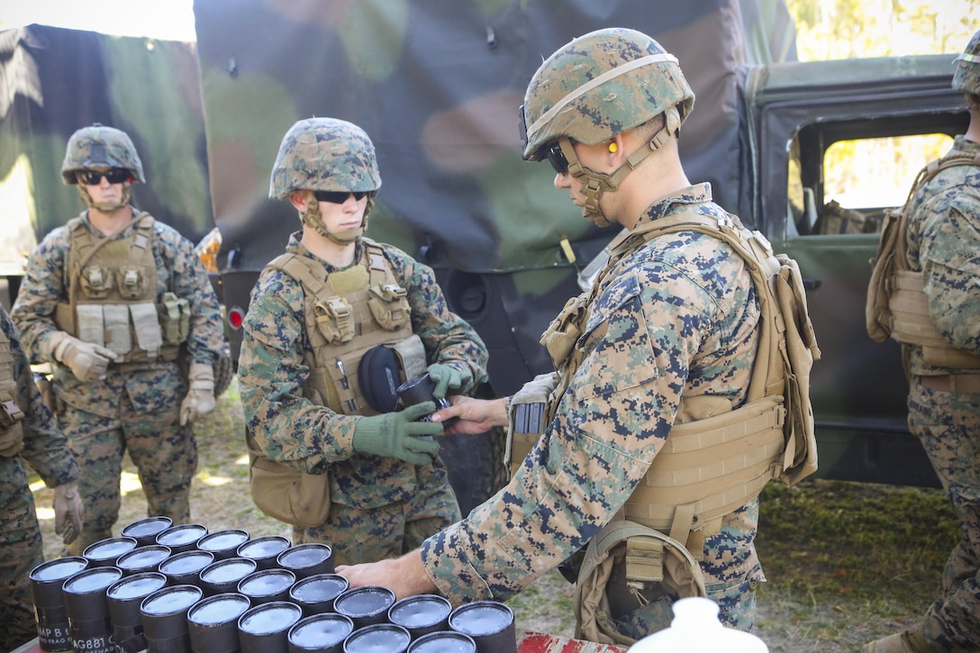 Marines with 2nd Law Enforcement Battalion receive their grenades before heading into the range pits at Camp Lejeune, N.C., March 16, 2016. This drill is part of an annual training event to prepare them for combat situations when they are called upon to deploy. Marines stood by the safety wall and waited to be escorted to the pits where they threw several grenades over the course of the afternoon. (U.S. Marine Corps photo by Lance Cpl. Aaron K. Fiala/Released)