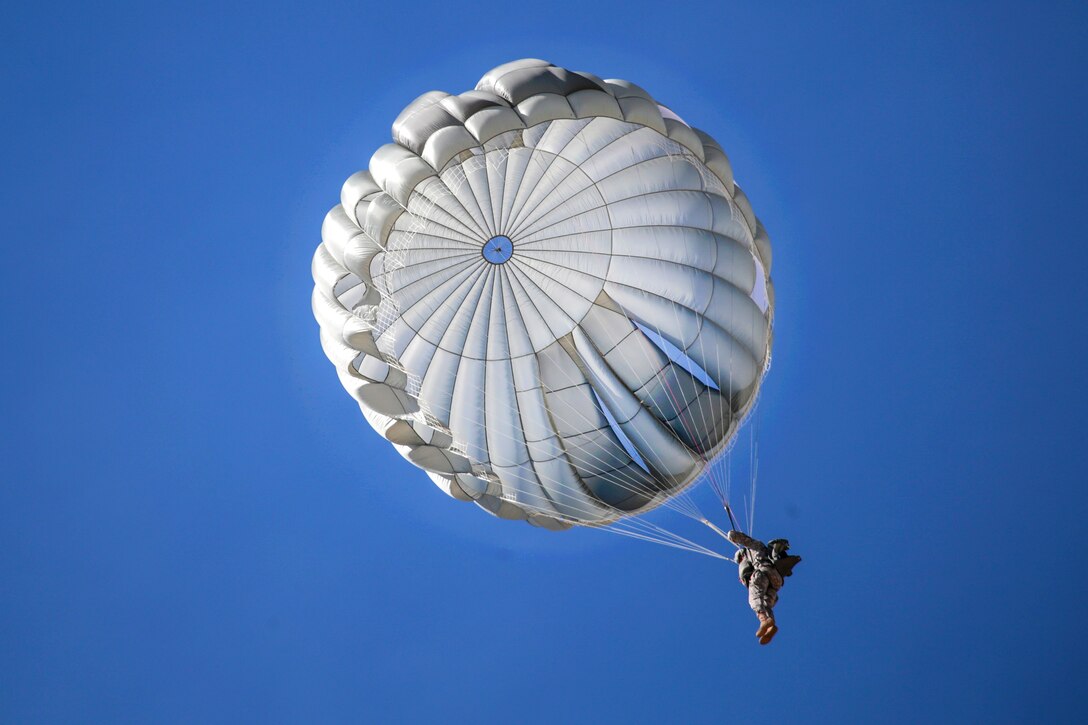 A paratrooper descends through the sky after jumping from a UH-60 Black Hawk helicopter during a parachute jump over Coyle drop zone on Joint Base McGuire-Dix-Lakehurst, N.J., March 12, 2016. New Jersey Air National Guard photo by Tech. Sgt. Matt Hecht 