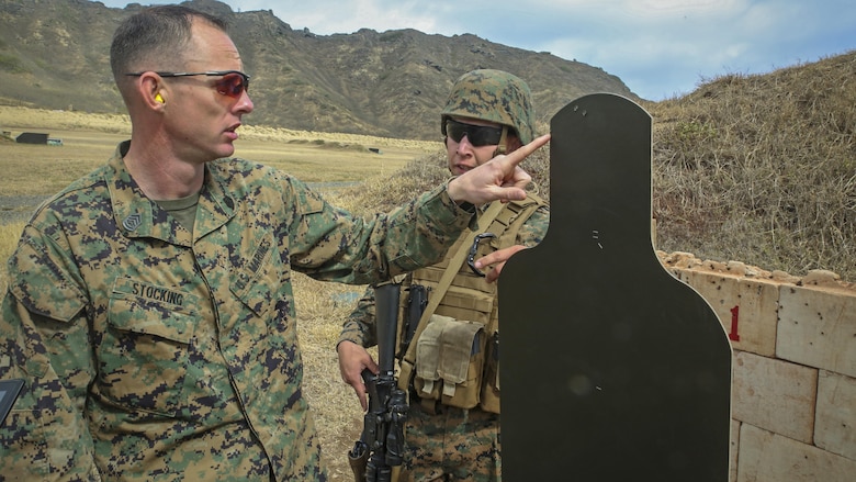Gunnery Sgt. Nathan Stocking, the officer in charge for the Marine Corps Combat Shooting Team and a Phoenix, Ariz., native, provides feedback to another Marine on his missed rounds during the Pacific Combat Shooting Match at the Kaneohe Bay Range Training Facility at Marine Corps Base Hawaii, March 16, 2016. Teams from different units used various weapons and tactics to achieve the fastest time possible on different courses of fire, while earning points for awards during the competition. Marines from the Marine Corps Combat Shooting Team instructed and gave advice to the Marines participating in the event. 