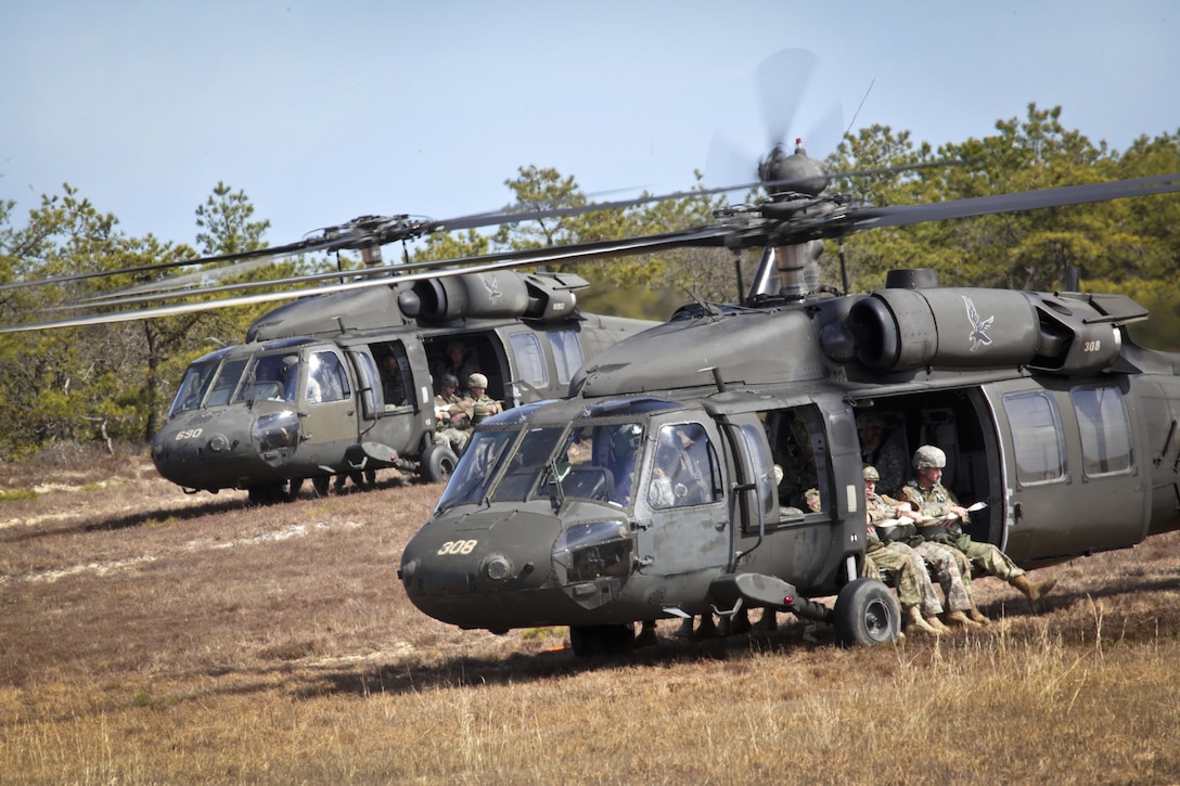 Two UH-60 Black Hawk helicopters prepare to lift off with paratroopers and airmen during a jump over Coyle drop zone on Joint Base McGuire-Dix-Lakehurst, N.J., March 12, 2016. The airmen are tactical air control party airmen assigned to the New Jersey Air National Guard. New Jersey Air National Guard photo by Tech. Sgt. Matt Hecht