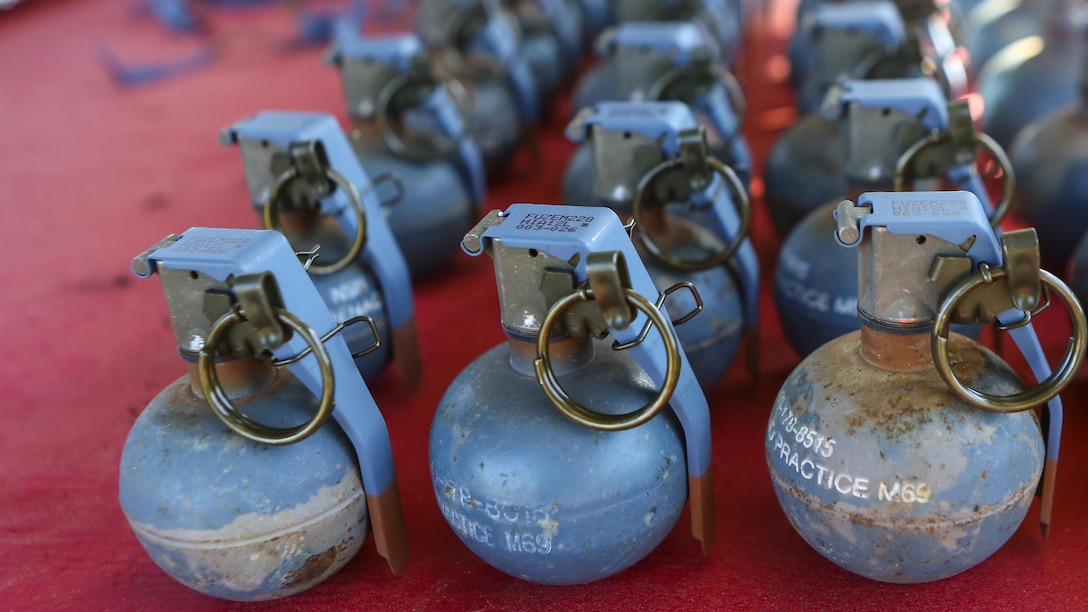 Inert grenades (dummy), non-exploding practice tools, sit on a table where Marines with 2nd Law Enforcement Battalion will pick them up before taking part in an assault course with grenade training at Marine Corps Base Camp Lejeune, N.C., March 16, 2016. This drill is part of an annual training event to prepare them for combat situations when they are called upon to deploy. Marines took turns providing cover fire for their partner, allowing them to throw a dummy grenade near the simulated enemy position.