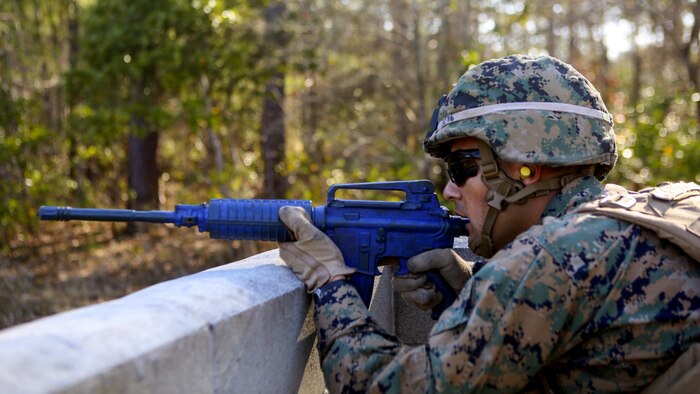 Lance Cpl. Arnaldo Avendano, a military policeman with 2nd Law Enforcement Battalion, takes a cover position during an assault course at Marine Corps Base Camp Lejeune, N.C., March 16, 2016. This drill is part of an annual training event to prepare them for combat situations when they are called upon to deploy. Marines took turns providing cover fire for their partner, allowing them to advance to the simulated enemy position. 
