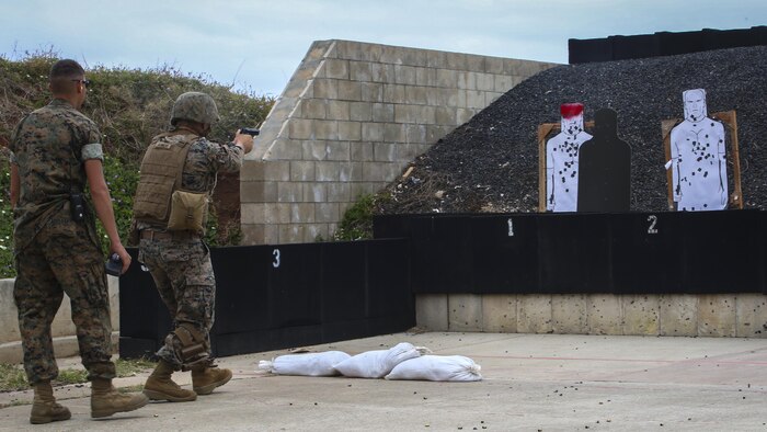Cpl. Zachary Summers, a radio operator with 3rd Radio Battalion, combat glides toward a target shooting his M9 Service Pistol during a Pacific Combat Shooting Match at the Kaneohe Bay Range Training Facility aboard Marine Corps Base Hawaii, March 16, 2016. Teams from different units used various weapons and tactics to achieve the fastest time possible on different courses of fire, while earning points for awards during the competition. Marines from the Marine Corps Combat Shooting Team instructed and gave advice to the Marines participating in the event.