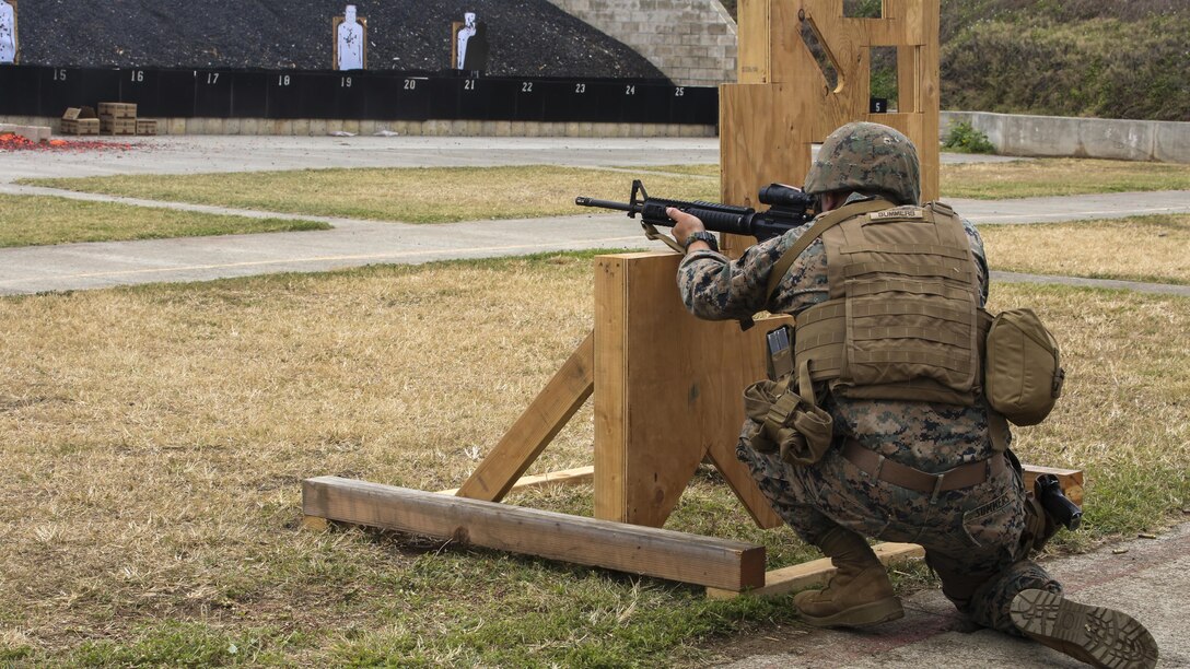 Cpl. Zachary Summers, a radio operator with 3rd Radio Battalion, kneels behind a barrier during a Pacific Combat Shooting Match at the Kaneohe Bay Range Training Facility at Marine Corps Base Hawaii, March 16, 2016. Teams from different units used various weapons and tactics to achieve the fastest time possible on different courses of fire, while earning points for awards during the competition. Marines from the Marine Corps Combat Shooting Team instructed and gave advice to the Marines participating in the event.