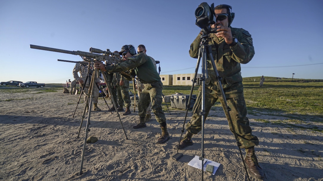 A sniper with the Special Operations Battalion, Brazilian Marine Corps, fires on targets from the standing position as his spotter observes his impacts through a range finder during a subject matter expert exchange with U.S. Marine Corps snipers from Training Cell, 1st Reconnaissance Battalion, 1st Marine Division, at Marine Corps Base Camp Pendleton, California, March 16, 2016. The exchange afforded Marines from both countries to come together and share knowledge and personal experiences with fellow snipers.