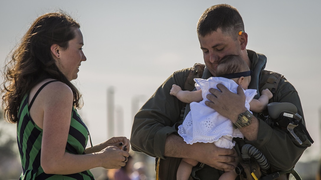 A pilot greets his family at Marine Corps Air Station Beaufort, South Carolina, March 15, 2016. More than 180 Marines and 10 F/A-18D Hornet aircraft have been deployed to the Western Pacific since October 2015 as part of the Unit Deployment Program. The pilot is with VMFA(AW)-224.