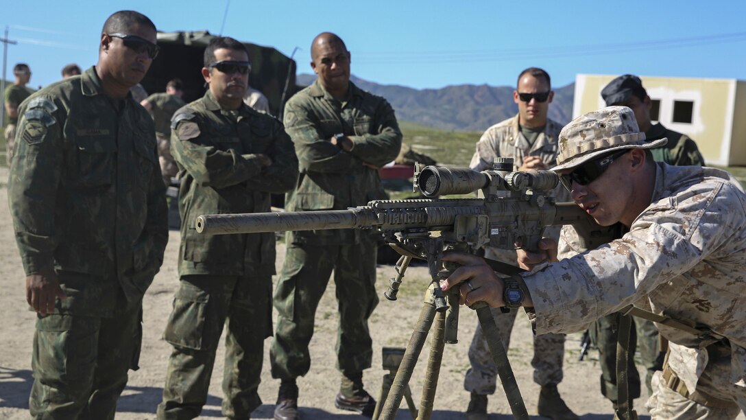 U.S. Marine Sgt. Jesse Kimble, an instructor with Training Cell, 1st Reconnaissance Battalion, 1st Marine Division, demonstrates a sniper’s standing firing position to snipers of the Special Operations Battalion, Brazilian Marine Corps, during a subject matter expert exchange at Marine Corps Base Camp Pendleton, California, March 16, 2016. Snipers from both countries gathered to exchange knowledge and experiences regarding techniques and procedures used by snipers from their respective militaries.