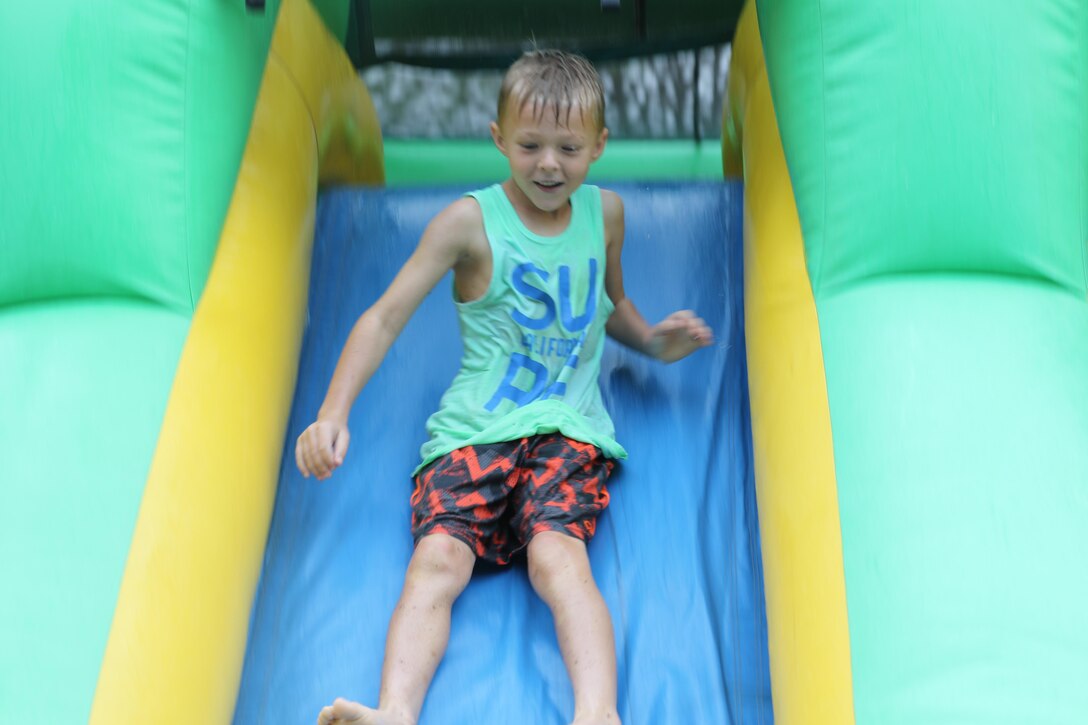 A young child slides down the blowup house slide during Recruiting Station Orlando’s Easter Family Day March 19, 2016, Lakeland, FL. The event brought Marines from every recruiting substation together in order to increase unit cohesion while enjoying a day together. 