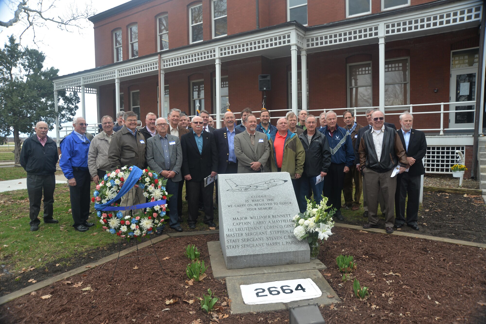 A few survivors of RC-135S Cobra Ball 664's last flight pose with other former members of the Air Force reconnaissance community March 15, 2016, next a monument at Offutt Air Force Base, Neb., honoring six Airmen who made the 
ultimate sacrifice 35 years ago when that aircraft crashed upon landing at Shemya Air Force Base, Alaska. The group attended the remembrance held outside the 45th Reconnaissance Squadron headquarters facility, where the monument resides.  (U.S. Air Force photo by Kendra Williams)
