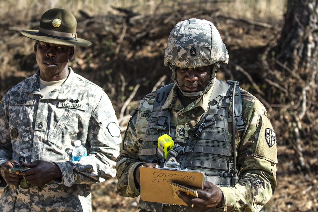 Army reserve drill sergeant, Sgt. 1st Class Maurice Tucker, left, watches as Army Sgt., 1st Class Maurice Francois consults his map during the land navigation exercise that's part of the Army Reserve Medical Command's 2016 Best Warrior competition on Fort Gordon, Ga., March 8, 2016. Tucker is assigned to the 98th Training Division’s, Company B, 1st Battalion, 321st Infantry Regiment, and Francois is assigned to the Medical Readiness Training Command, Army Reserve Medical Command. Army photo by Sgt. 1st Class Brian Hamilton