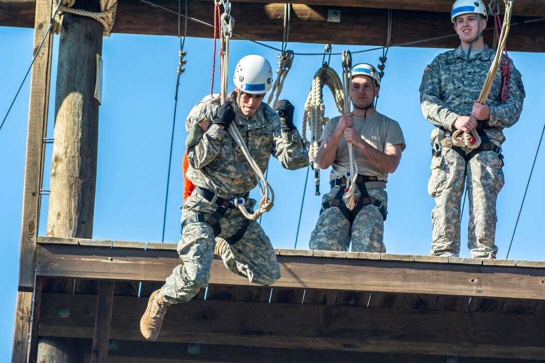 Army Spc. Christopher Ubias, left, rides an aip line to the ground during a team building exercise that's part of the Army Reserve Medical Command's 2016 Best Warrior competition on Fort Gordon, Ga., March 8, 2016. Ubias is assigned to the Western Medical Area Readiness Support Group, Army Reserve Medical Command. Army photo by Sgt. 1st Class Brian Hamilton