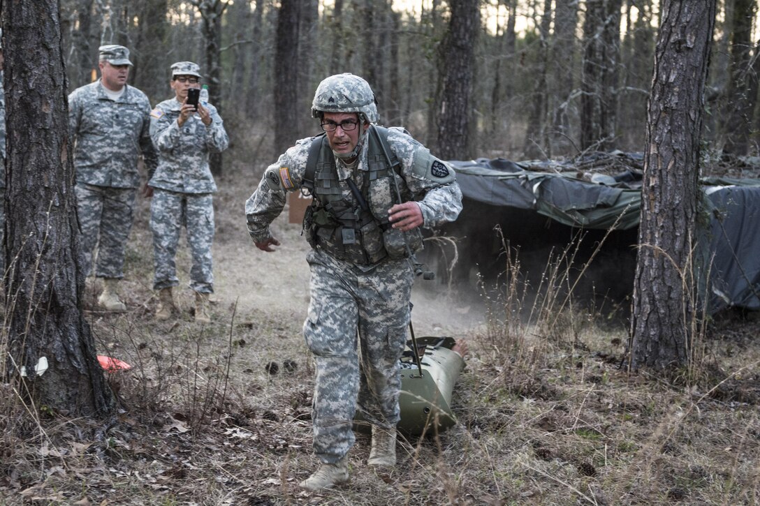 Army Sgt. Abraham Amabisca, foreground, pulls a basic rescue system loaded with a 40-pound mannequin through an obstacle course during the Army Reserve Medical Command's 2016 Best Warrior competition on Fort Gordon, Ga., March 8, 2016. Amabisca is assigned to the Medical Readiness Training Command, Army Reserve Medical Command. Army photo by Sgt. 1st Class Brian Hamilton
