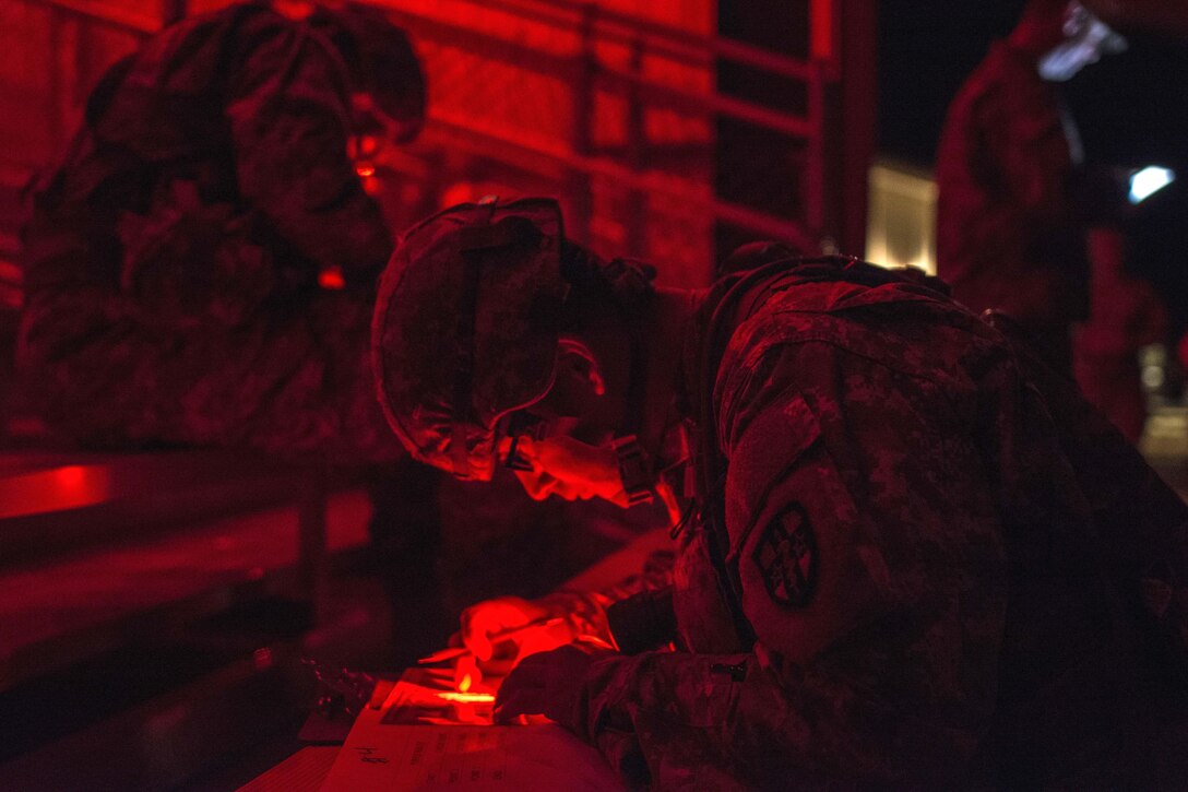 Army Sgt. Abraham Amabisca plots points on a map before negotiating the night land navigation course that's part of the Army Reserve Medical Command's 2016 Best Warrior competition on Fort Gordon, Ga., March 8, 2016. Amabisca is assigned to the Medical Readiness Training Command, Army Reserve Medical Command. Army photo by Sgt. 1st Class Brian Hamilton
