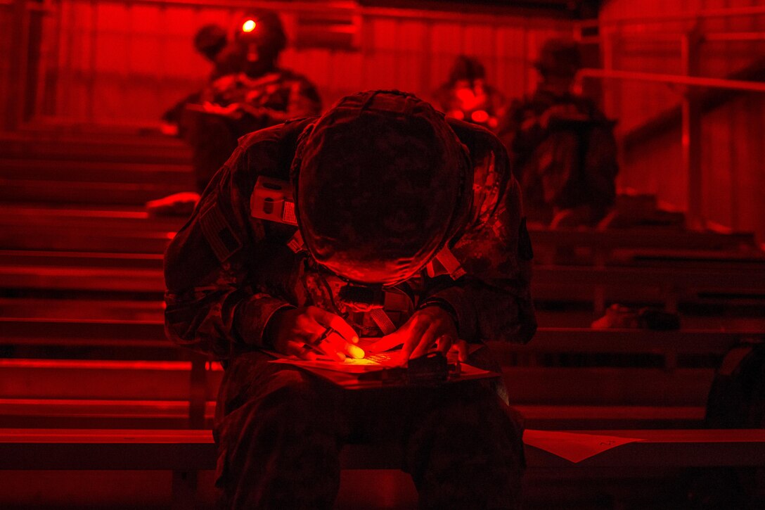 Army reservists plot their points on a map using infrared lighting before negotiating the night land navigation course that's part of the Army Reserve Medical Command's 2016 Best Warrior competition on Fort Gordon, Ga., March 8, 2016. Army photo by Sgt. 1st Class Brian Hamilton