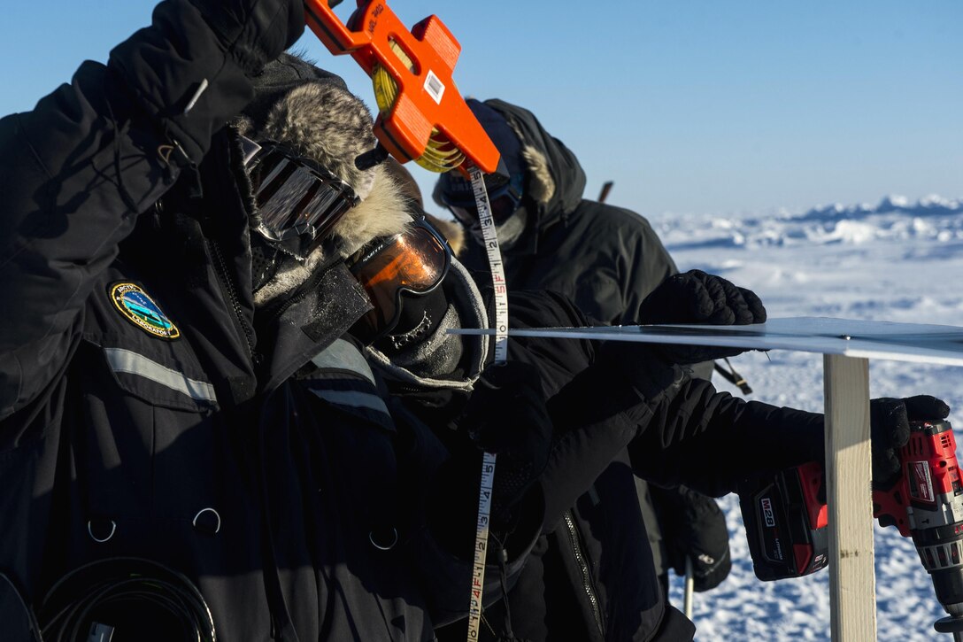 Dr. Andrei Abelev, left, and Dr. Joan Gardener, with the Naval Research Laboratory, measure ice thickness during Ice Exercise 2016 at Ice Camp Sargo, Arctic Circle, March 8, 2016. Navy photo by Petty Officer 2nd Class Tyler N. Thompson