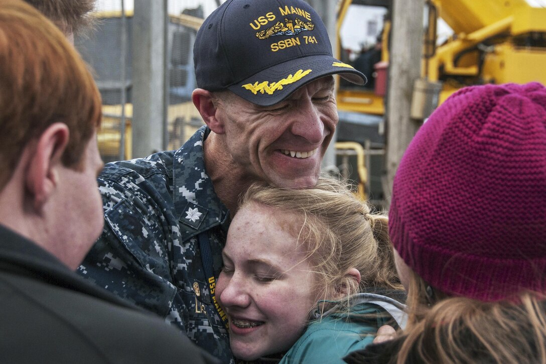 Navy Cmdr. Kelly Laing exchanges smiles and hugs as he returns home to Naval Base Kitsap, Wash., March 16, 2016. Laing is commanding officer of the blue crew of the ballistic-missile submarine USS Maine, which returned to the base following a routine strategic deterrent patrol. Navy photo by Petty Officer 2nd Class Amanda R. Gray