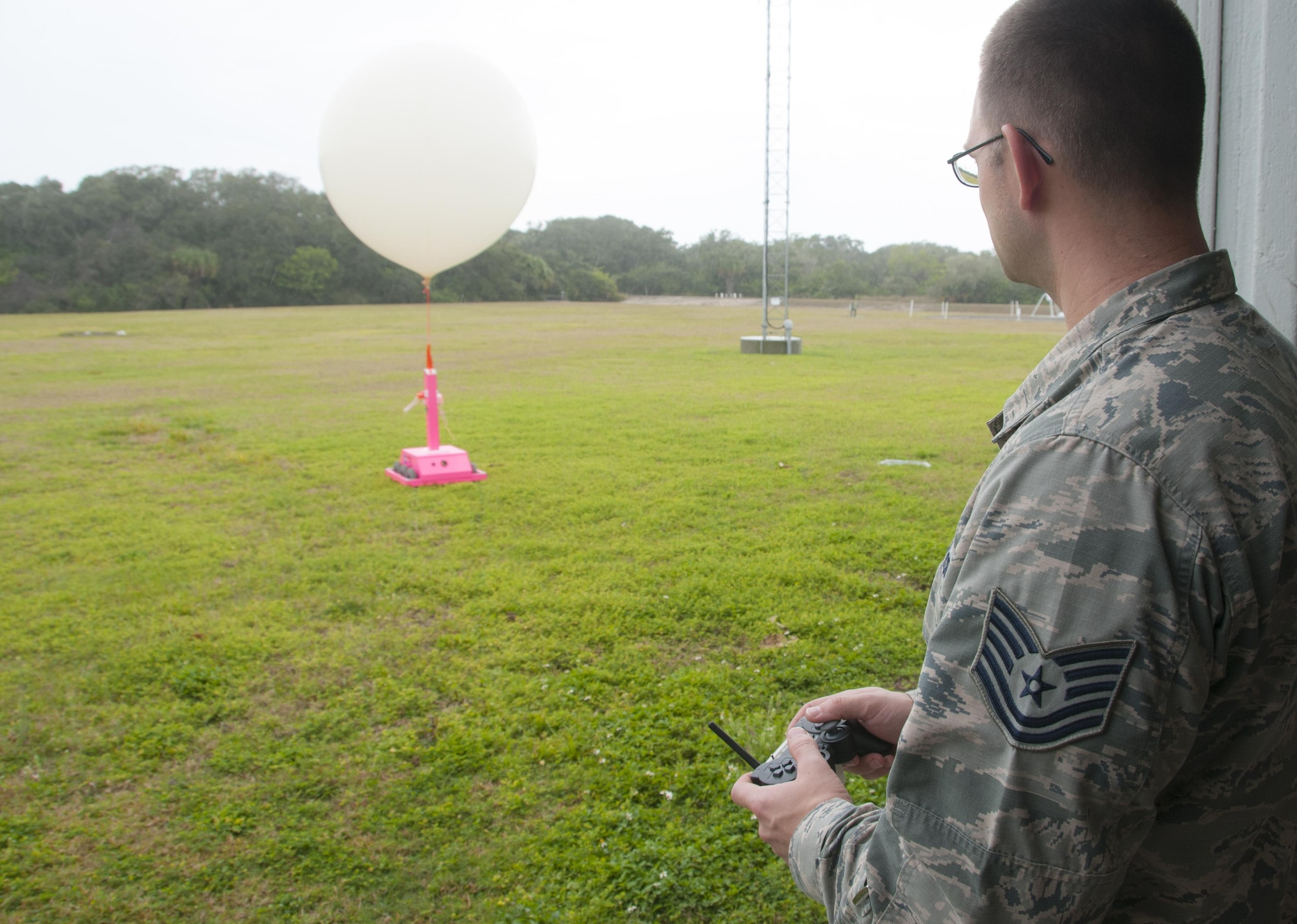Tech Sgt. Matthew Mong, a 45th Weather Squadron range weather forecaster, demonstrates how to use a “weatherbot” at the weather balloon facility on Cape Canaveral Air Force Station, Fla., Feb. 24, 2016. The remote-controlled robot releases balloons when lightning is present so forecasters can stay safely indoors. Data from the balloons, particularly wind speed and direction, help Airmen and mission partners decide either to launch or postpone a space mission. (U.S. Air Force photo/Sean Kimmons)
