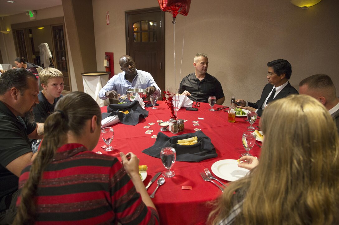 Marines and families with Communication Training Battalion, Marine Corps Communication-Electronics School, enjoy dinner together during the battalion’s first anniversary celebration at the Officer’s Club March 10, 2016. The battalion, activated March 12, 2015, brought the training of enlisted and commissioned communication Marines under one command. (Official Marine Corps photo by Lance Cpl. Levi Schultz/Released)