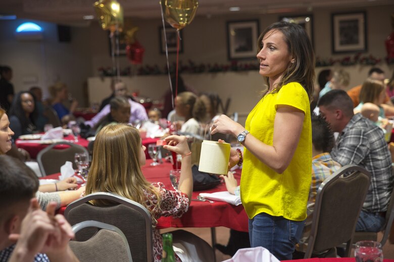 Bree Koumparakis, wife of Lt. Col. Speros C. Koumparakis, commanding officer, Communication Training Battalion, pulls raffle tickets during the battalion’s first anniversary celebration at the Officer’s Club March 10, 2016. The battalion, activated March 12, 2015, brought the training of enlisted and commissioned communication Marines under one command. (Official Marine Corps photo by Lance Cpl. Levi Schultz/Released)