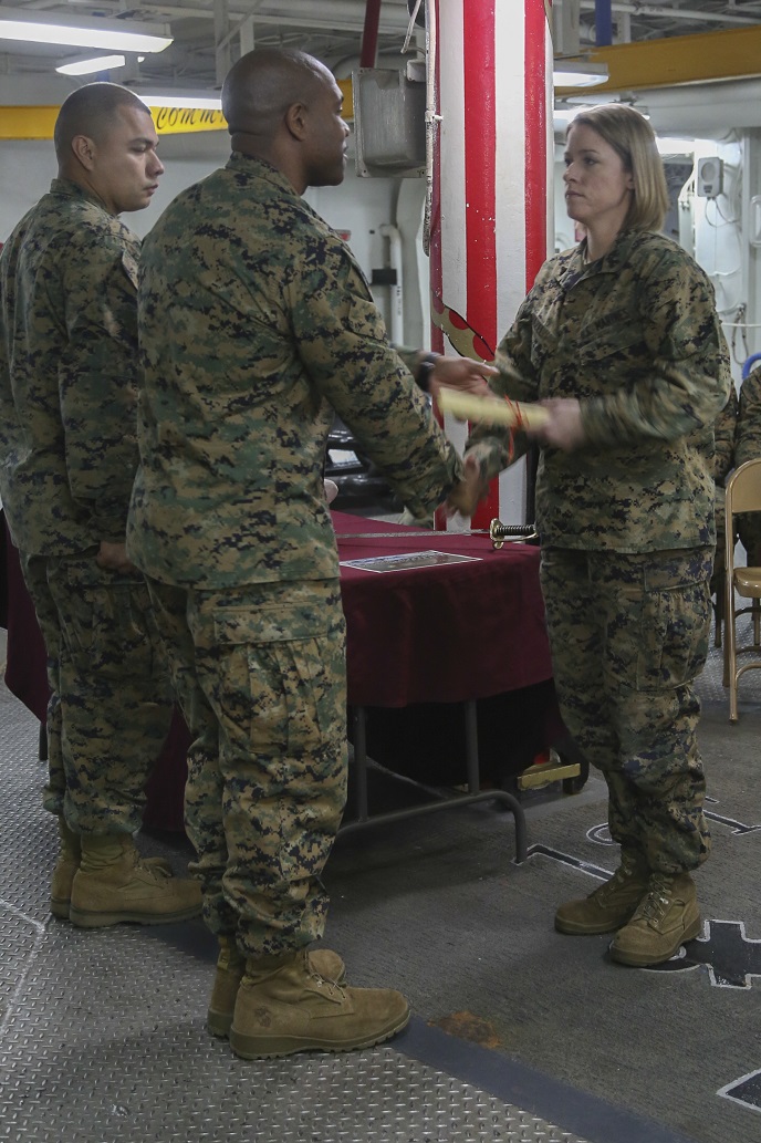 At sea. (March 18, 2016)-U.S. Marine Master Sgt. Jason Evans with the 13th Marine Expeditionary Unit presents Cpl. Catherine Hazel with a certificate of completion during the Corporal's Course 374-16's graduation ceremony March 18, 2016, during the MEU's Western Pacific deployment aboard the USS Boxer. More then 4,500 Marines and Sailors from the Boxer Amphibious Ready Group, 13th MEU team are currently transiting the Pacific Ocean toward the U.S. 7th fleet are of operations during a scheduled deployment. (U.S. Marine Corps photo by Sgt. Briauna Birl/RELEASED)
