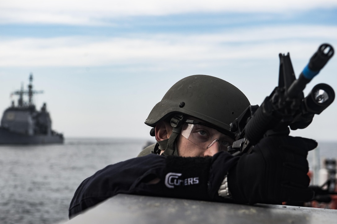 A sailor provides forward cover during a training exercise in the Atlantic Ocean, March 17, 2016. The sailor is a member of the visit, board, search and seizure team aboard the USS San Jacinto. The guided-missile cruiser is conducting the exercise with the Dwight D. Eisenhower Carrier Strike Group to prepare for a future deployment. U.S. Navy photo by Petty Officer 3rd Ryan U. Kledzik
