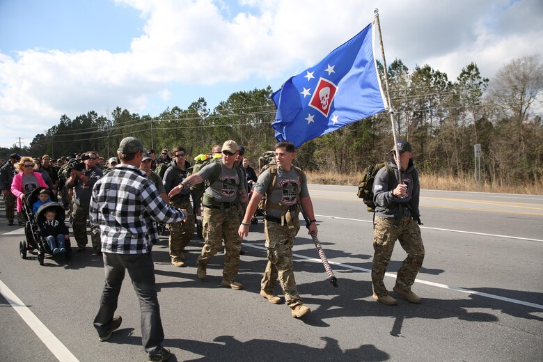The local community lined the streets and cheered on the ruckers as they finished the Marine Raider Memorial March outside the Stone Bay main gate, aboard Marine Corps Base Camp Lejeune, N.C., March 21, 2016.  The Marine Raider Memorial March was designed to honor the seven Marine Raiders who died on March 10th, 2015 and their families, as well as bring awareness to their sacrifice. The ruckers were made up of both active duty and former Raiders, family members, and close friends. Following the conclusion of the March there was a short ceremony to honor the fallen. 