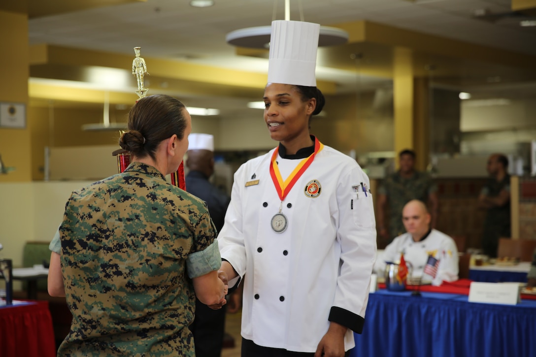 Sgt. Fatimah Butler accepts the first place medal from Lt. Col. Ginger E. Beals, commanding officer of MWSS-271 for the Chef of the Quarter Competition at the Marine Corps Air Station Cherry Point, N.C., mess hall, March 17, 2016. Three Marines competed this quarter, and Butler was named the winner. Butler will move on to the Chef of the Year Competition and compete with the other Chef of the Quarter winners. (U.S. Marine Corps photo by Lance Cpl. Mackenzie Gibson/Released)