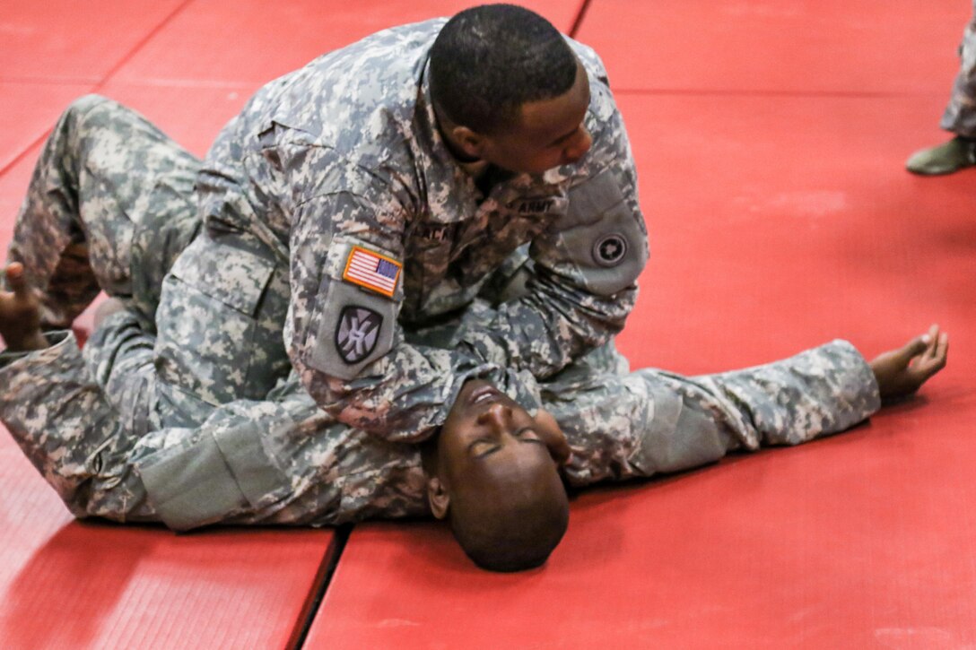 Sgt. 1st Class Charles Blackmon, 311th Sustainment Command (Expeditionary), demonstrates the Cross Collar Choke with Sgt. Patrick Williams, 326th Financial Management Support Center, during the 311th's Best Warrior Competition, Camp Pendleton, Calif., March 18, 2016. 6,400 Army Reserve Soldiers from throughout Arizona, California, and Nevada are part of the 311th ESC which provides deployed logistics command, control, and operational sustainment support. The top  Soldier and Noncommisioned Officer will advance to compete at the 79th Sustainmen Support Command BWC in April. (U.S. Army photo by Spc. Timothy Yao/Released)