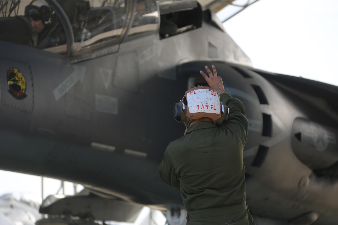 Lance Cpl. Viral Patel communicates with an TAV-8B Harrier crewmembers prior to take off at Marine Corps Air Station Cherry Point, N.C., March 11, 2016. A plane captain is responsible for conducting a final examination of the aircraft and guiding the pilots out onto the runway. Plane captains possess extensive knowledge of their designated aircraft and can determine if there are any last minute discrepancies that could potentially ground the aircraft. Patel is a plane captain and a fixed-wing aircraft mechanic with Marine Attack Training Squadron 203. (U.S. Marine Corps photo by Cpl. N.W. Huertas/Released)

